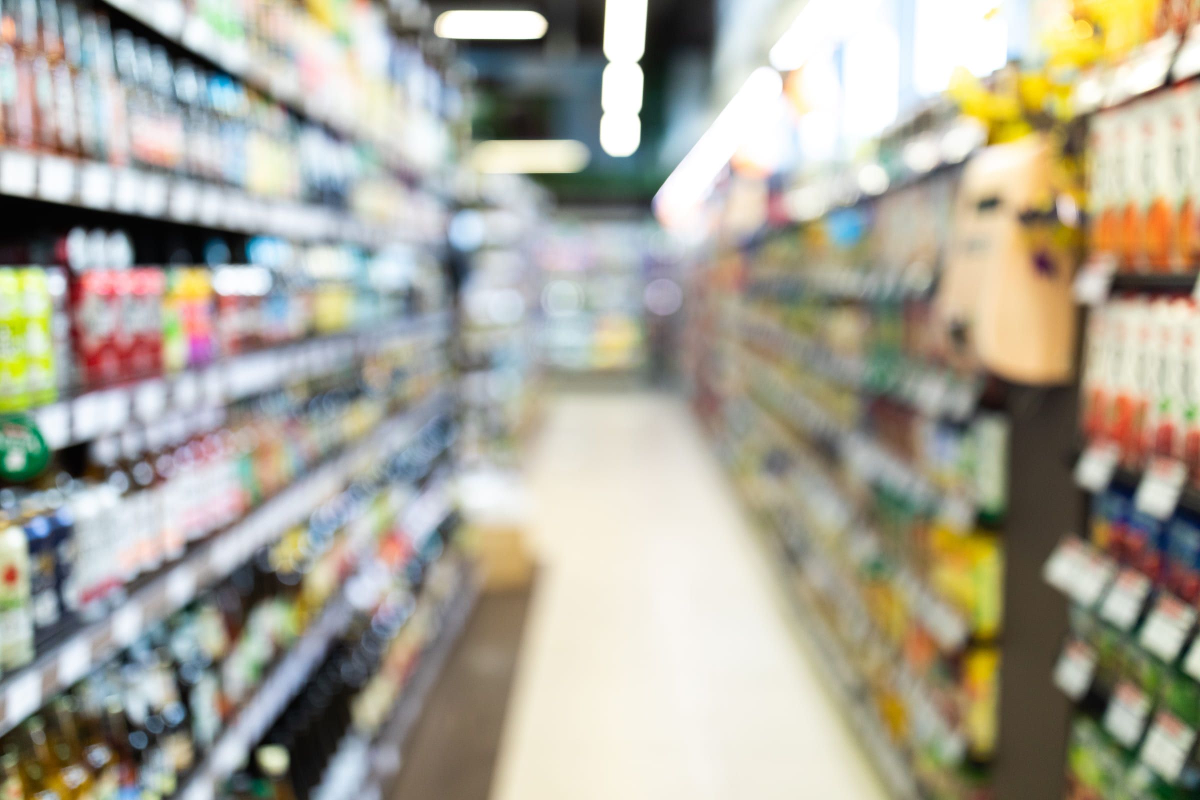 A supermarket drinks aisle, thrown out of focus.